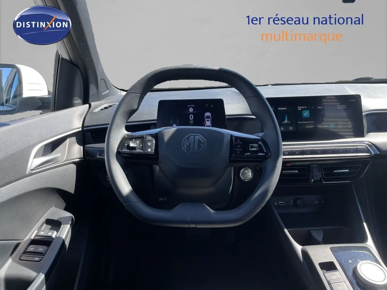 Vue intérieure centrée sur le volant MG d'une MG3 Dover White 2025, avec tableau de bord numérique et écran tactile.