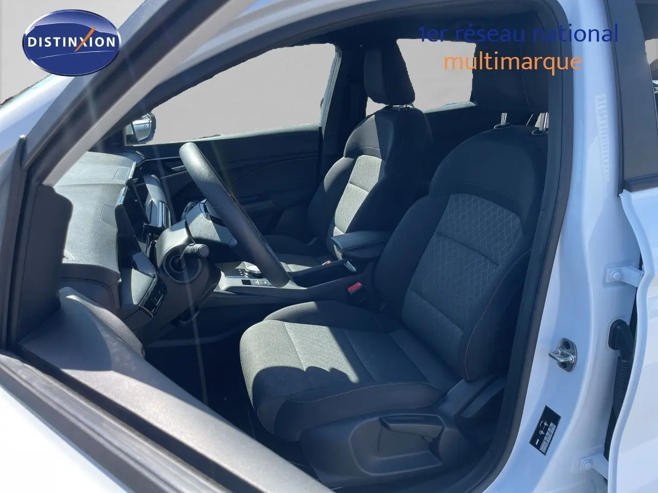 Vue intérieure côté conducteur du MG3 2025 blanc Dover, avec sièges tissu noir et volant multifonction.