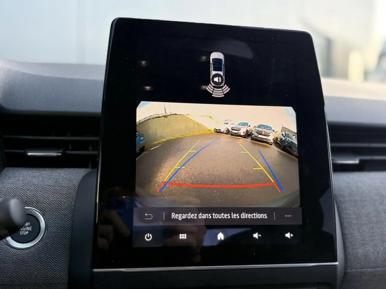 Écran tactile central montrant la caméra de recul avec guidage, intérieur gris du Renault Clio 2025 vue de face.