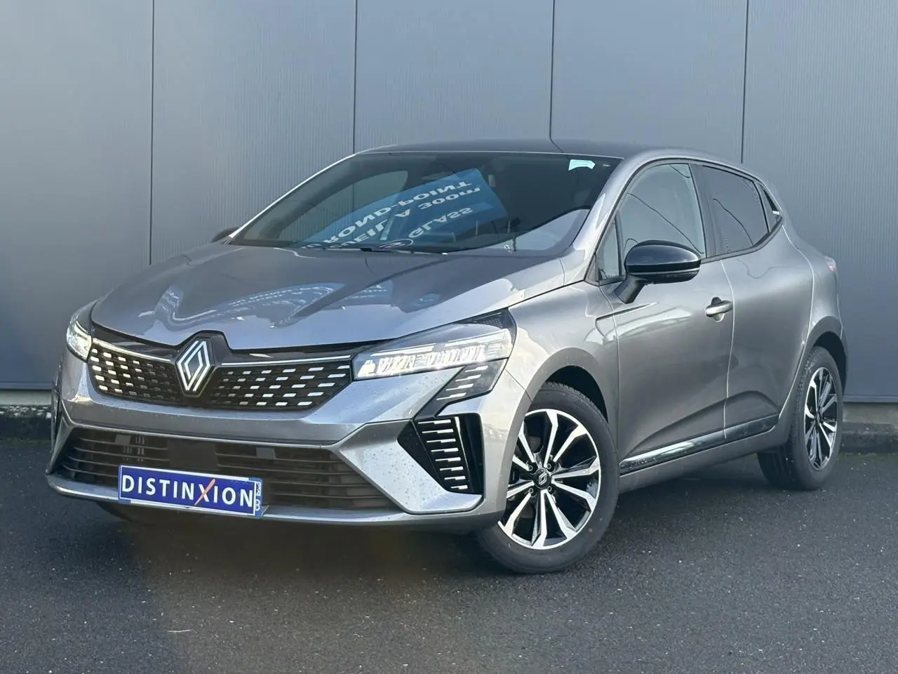 Renault Clio V TCE 90 Techno gris schiste vue 3/4 avant avec jantes alliage et calandre distinctive.