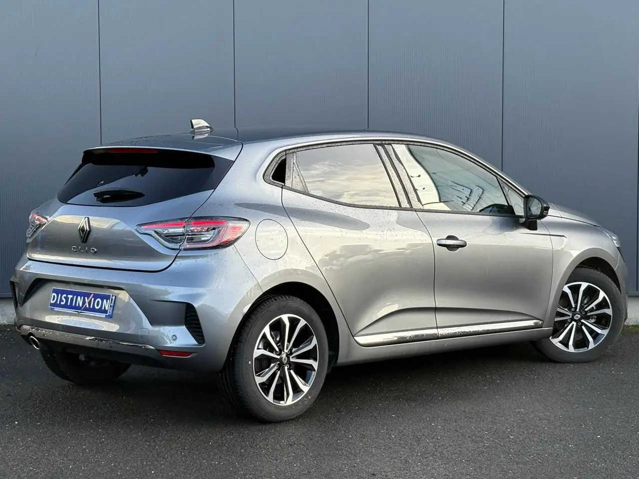 Vue 3/4 arrière droite d'une Renault Clio gris schiste avec jantes alliage et vitres surteintées.