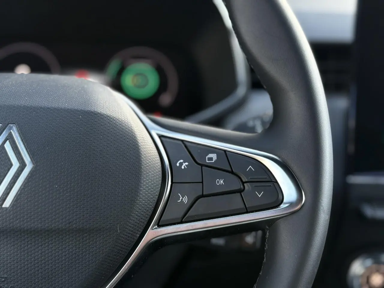 Gros plan sur les commandes multifonctions à droite du volant noir de la Renault Clio V TCe 90 Techno 2025.
