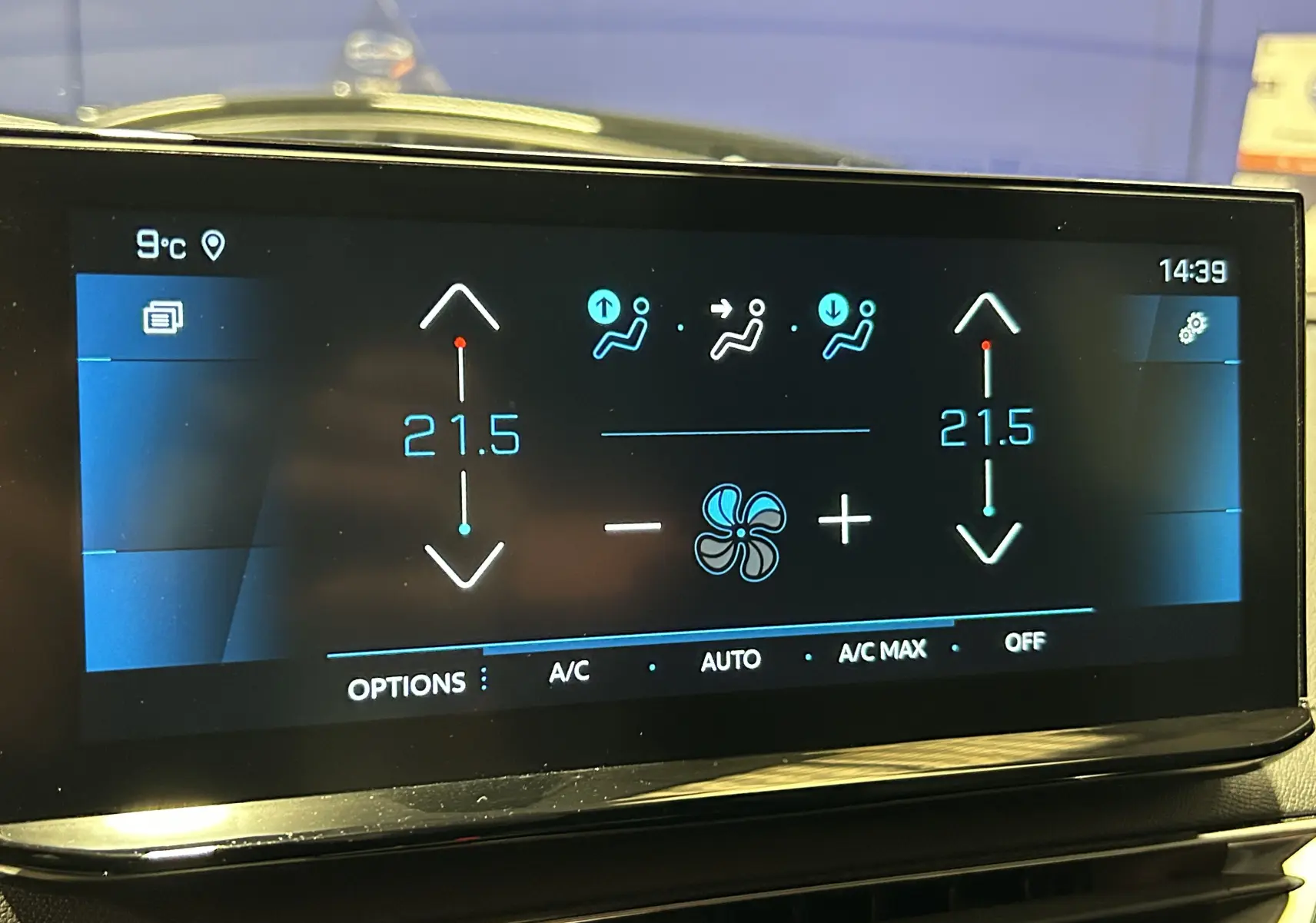 Écran tactile central du tableau de bord du Peugeot 3008 gris, affichant la climatisation à 21,5°C en double zone.