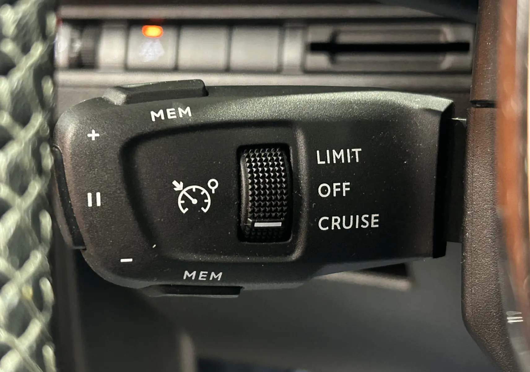 Gros plan sur la commande de régulateur de vitesse du Peugeot 3008 Puretech 130, intérieur noir avec volant cuir.