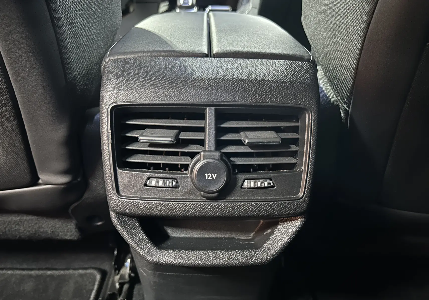 Gros plan sur la sortie d’air arrière avec prise 12V du Peugeot 3008 gris Artense, intérieur noir.