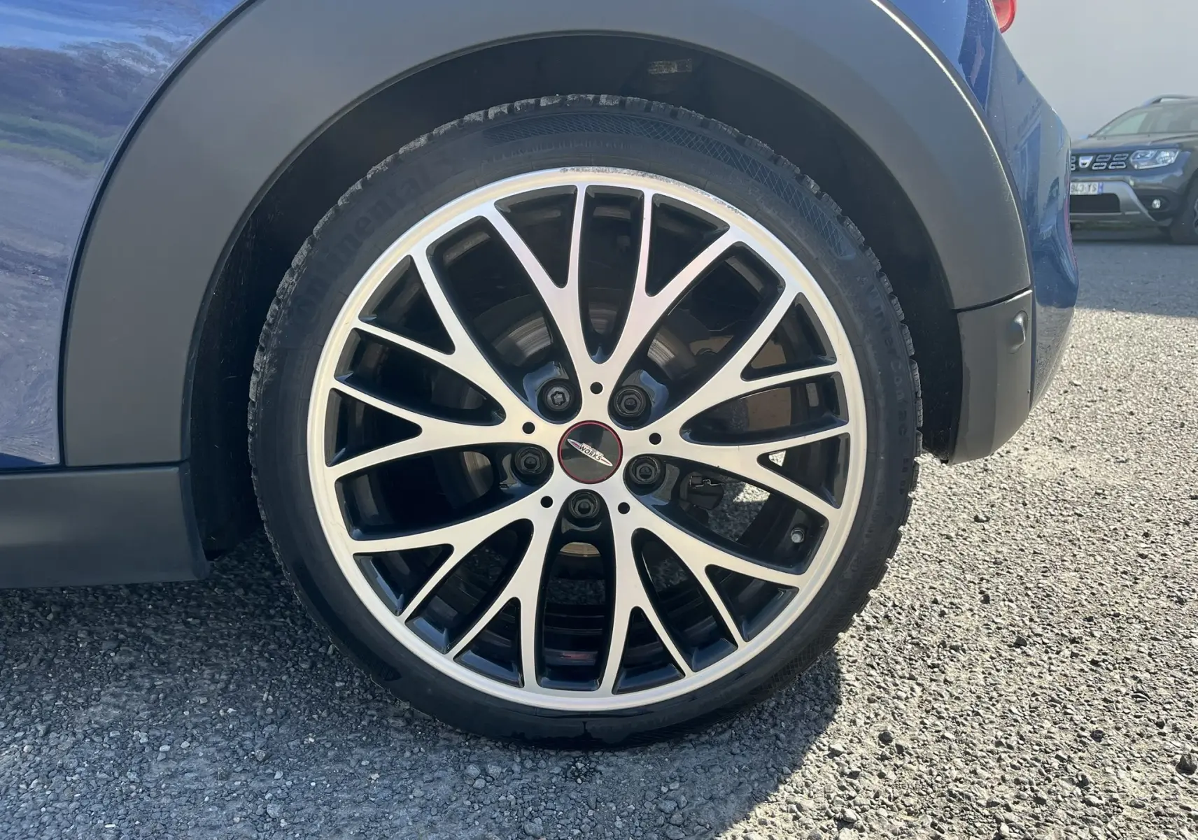 Gros plan sur la roue arrière droite de la MINI Cabriolet F57 Cooper S bleu, avec jante alliage noire et argentée au design fin.
