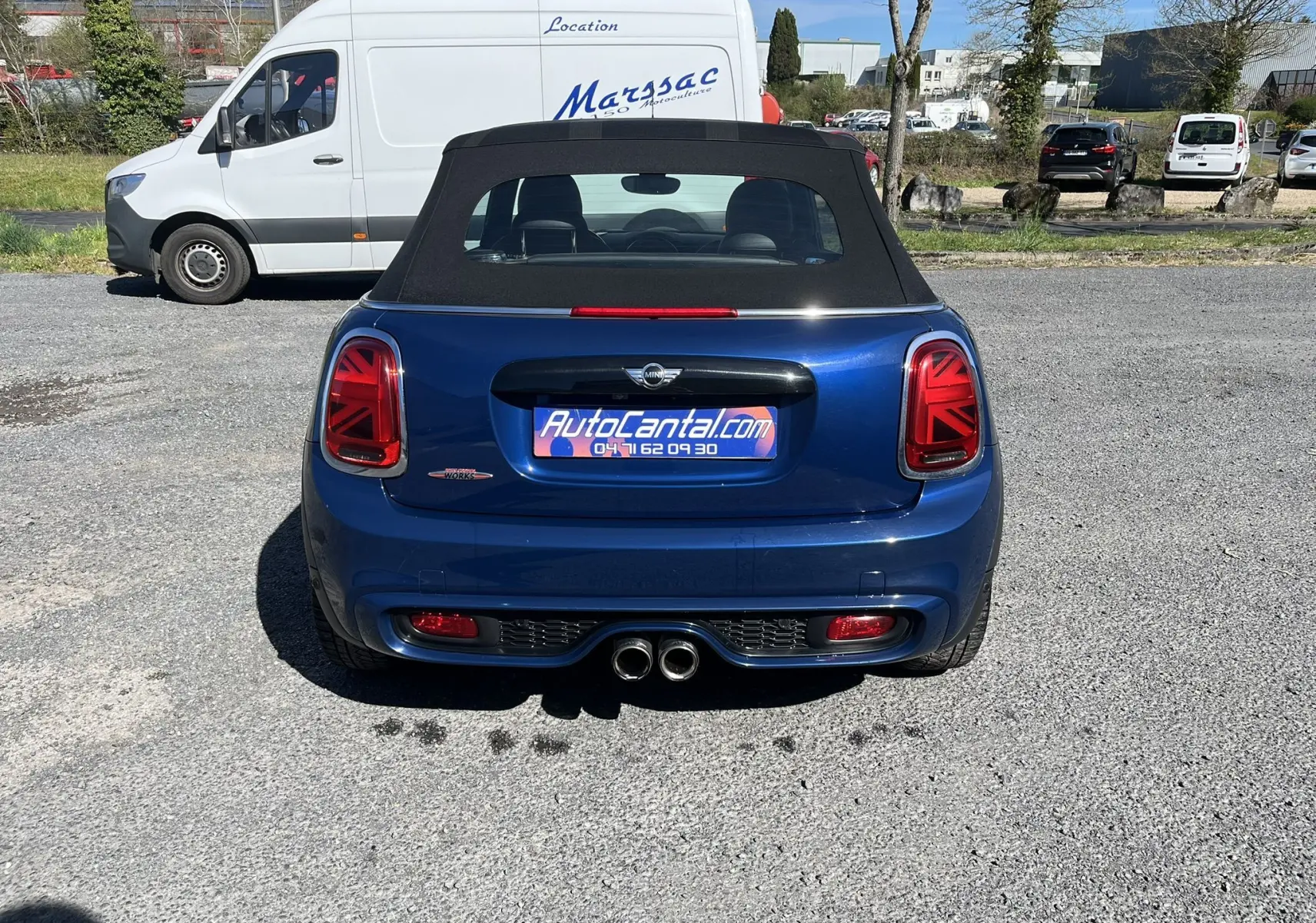 Vue arrière d'une MINI Cabriolet F57 Cooper S bleu avec capote noire et feux arrière à motif Union Jack.