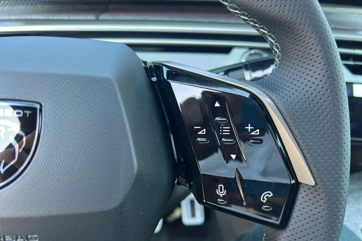 Gros plan sur la commande multifonctions droite du volant cuir perforé du Peugeot 3008 New Hybrid gris titane.