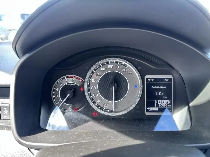 Vue rapprochée du tableau de bord de la Suzuki Ignis beige 2023, affichant le compteur de vitesse et l'autonomie.