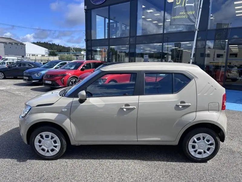 Vue latérale droite d'une Suzuki Ignis beige 2023, version 1.2 Dualjet Hybrid avec jantes acier et carrosserie compacte.