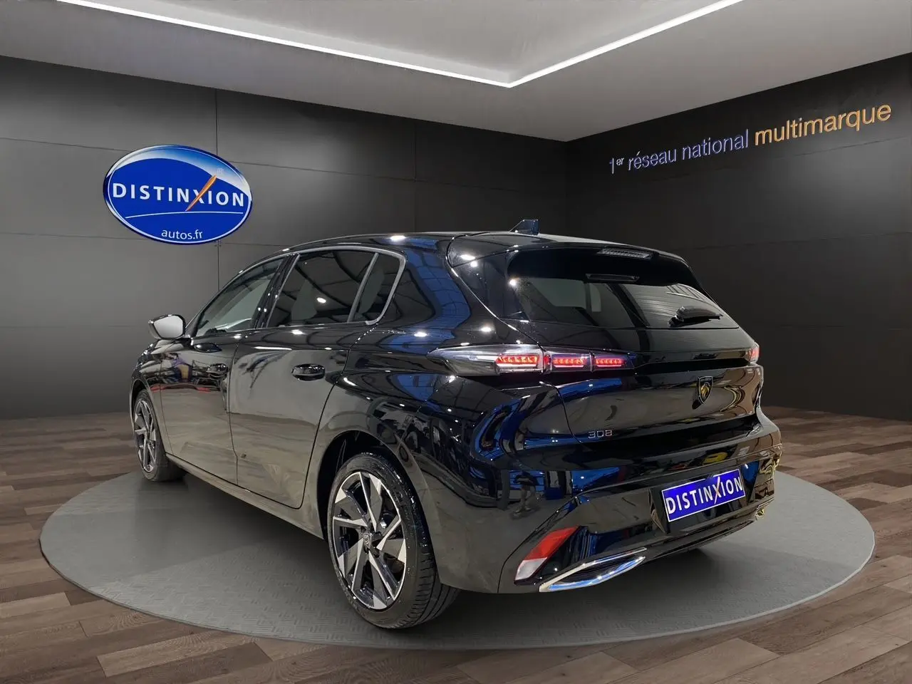 PEUGEOT 308 noir perla nera vue 3/4 arrière droit en intérieur avec feux arrière LED allumés.