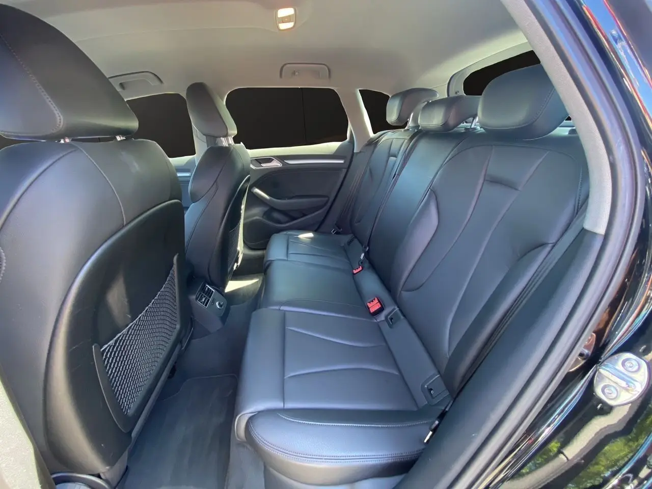 Vue intérieure arrière côté droit de l'Audi A3 Sportback noire 2020 avec sellerie cuir noir et sièges chauffants.