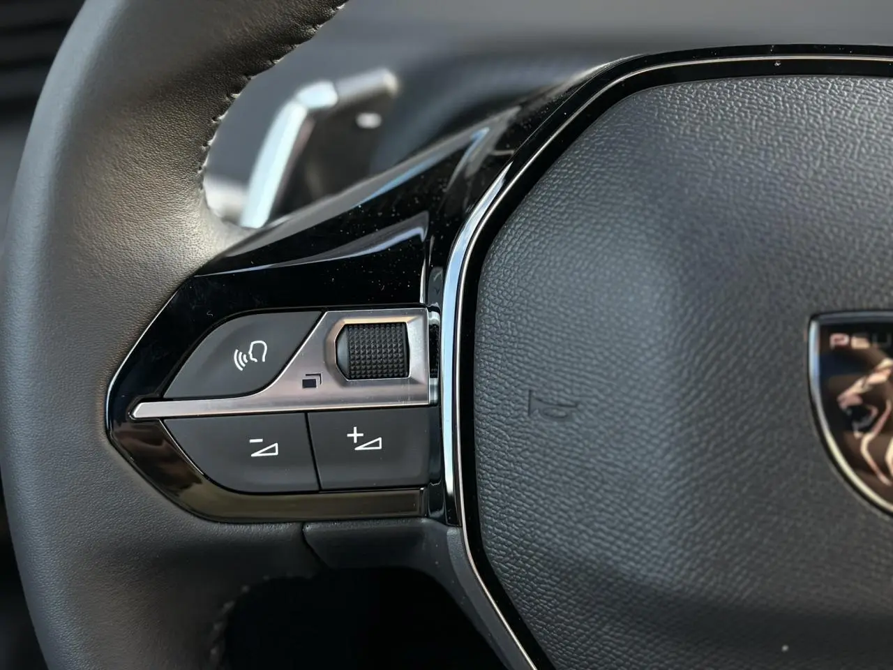 Gros plan sur la partie gauche du volant cuir noir du Peugeot 2008 Hybrid 145 e-DSC6 Allure 2025.
