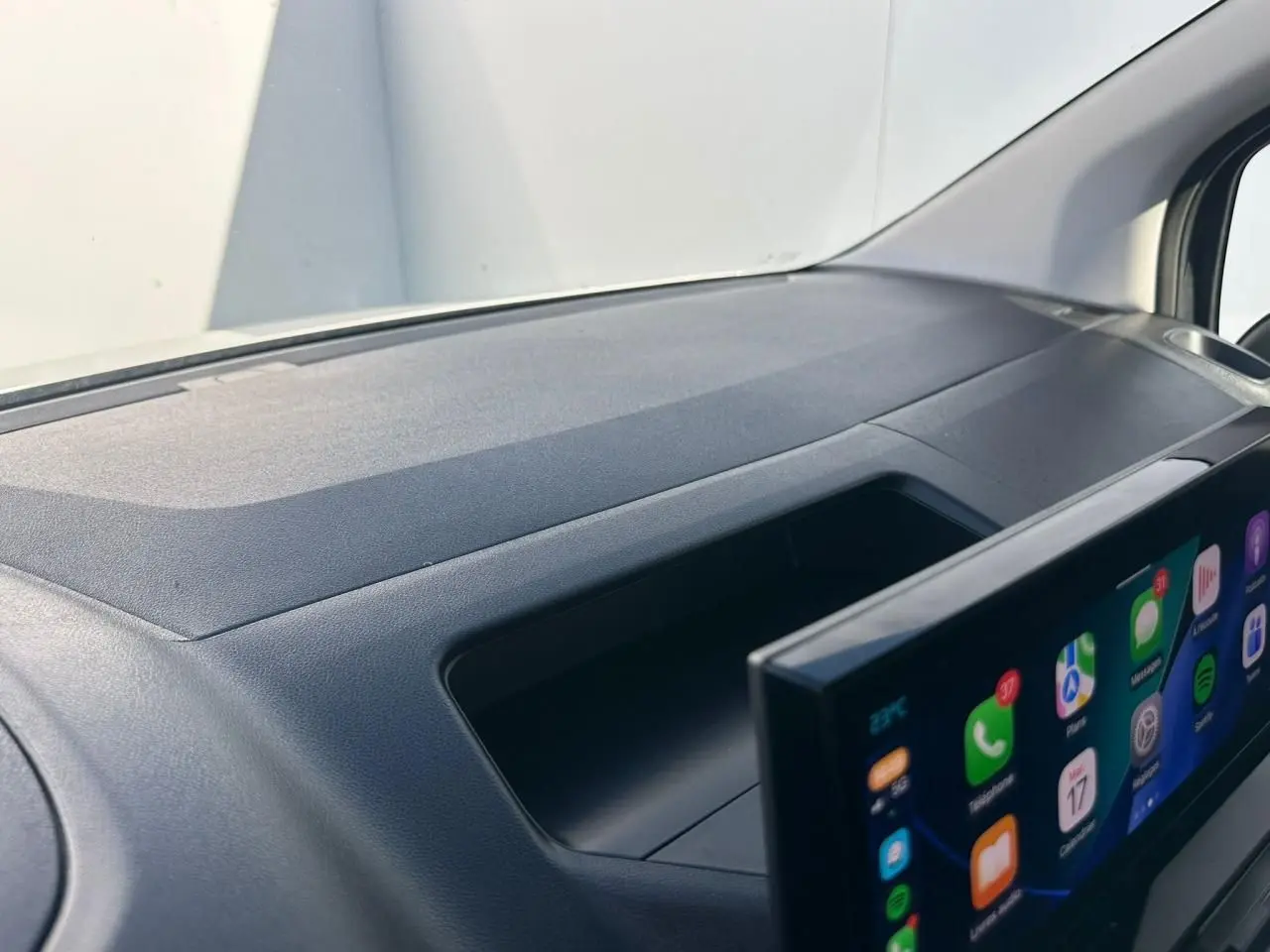 Vue rapprochée de la planche de bord noire du Citroën Berlingo III avec écran tactile 10 pouces en premier plan.