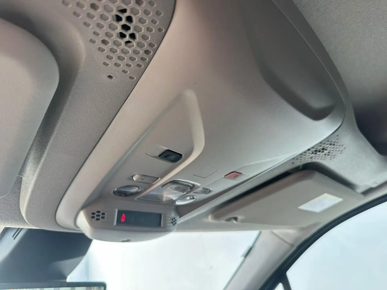 Vue intérieure en gros plan du plafonnier gris clair du Citroën Berlingo III blanc Icy avec commandes intégrées.