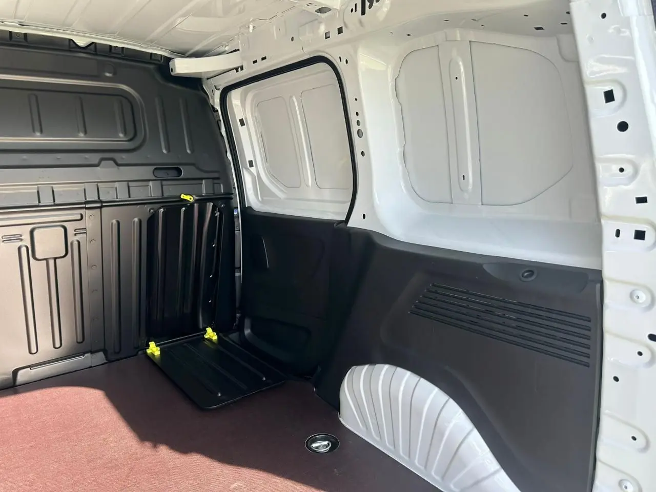 Vue intérieure côté droit du coffre blanc icy du Citroën Berlingo III Van avec plancher bois antidérapant et cloison fixe.