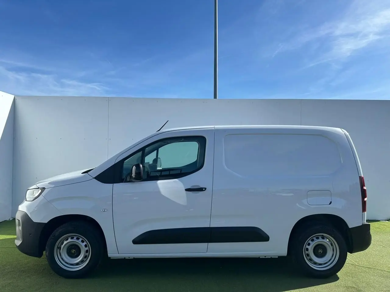 Profil latéral droit du Citroën Berlingo blanc Icy, fourgon compact avec jantes tôle grises et rétroviseurs noirs brillants.