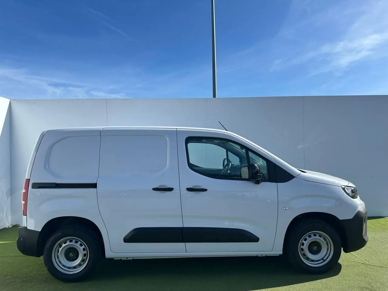 Profil droit du Citroën Berlingo III blanc Icy, fourgon utilitaire avec protections noires et jantes tôle grises.