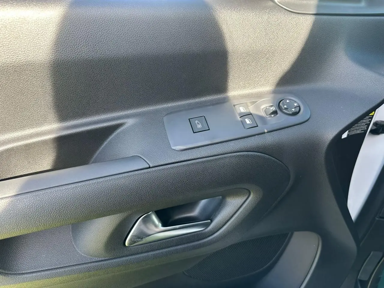 Gros plan sur la porte côté conducteur du Citroën Berlingo blanc Icy, avec commandes électriques des vitres et rétroviseurs.