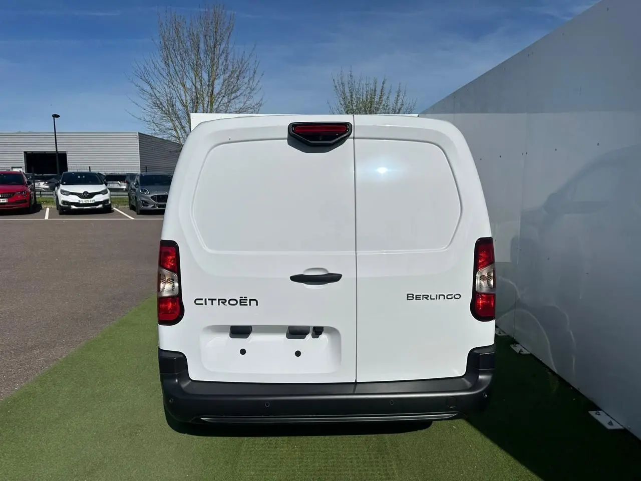 Vue arrière d'un utilitaire Citroën Berlingo blanc Icy avec portes battantes et pare-chocs noir.