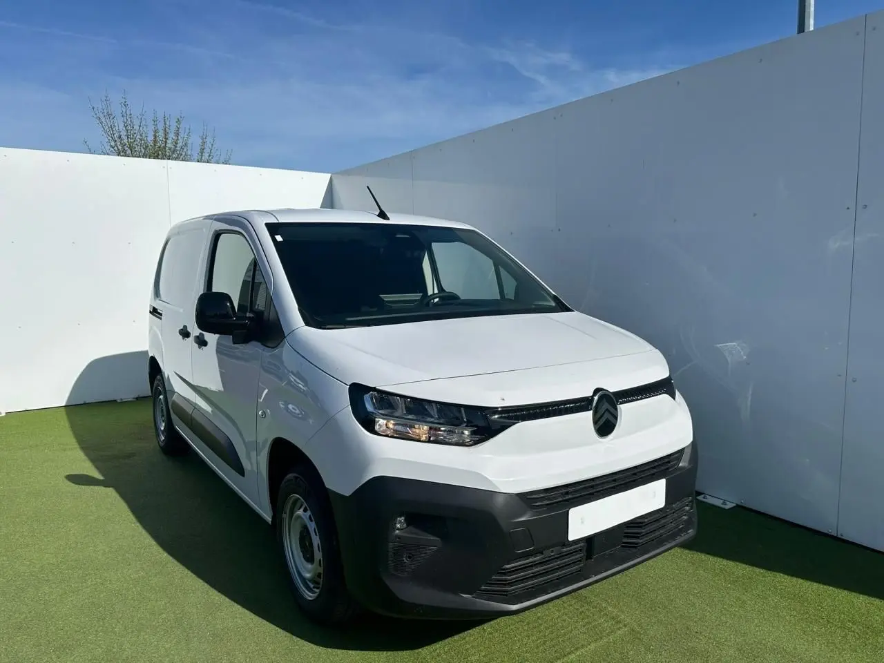 Vue 3/4 avant d’un utilitaire Citroën Berlingo blanc Icy avec pare-chocs noir mat et jantes tôle grises.
