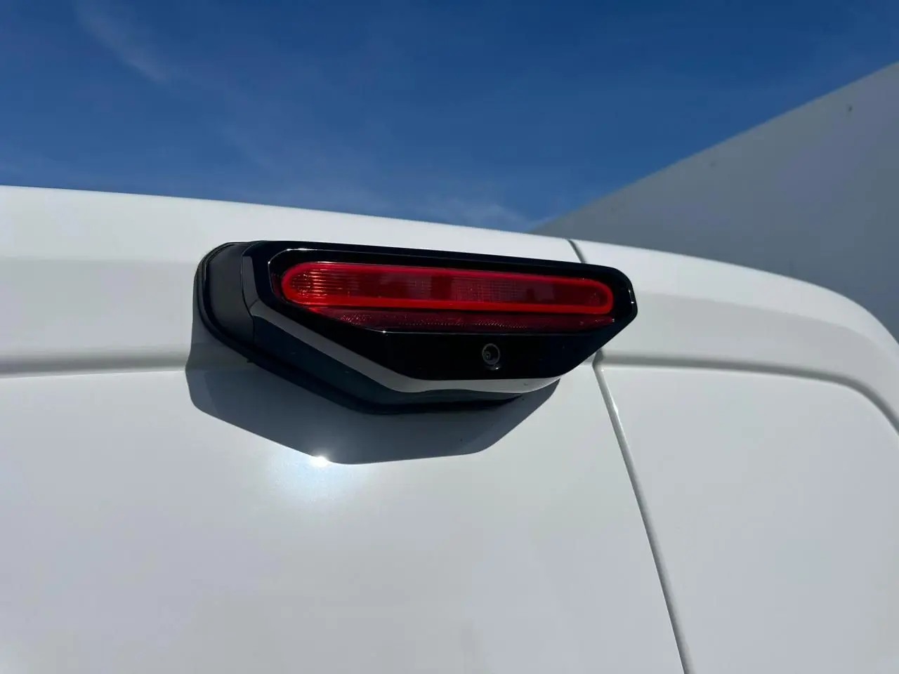 Gros plan sur le feu arrière supérieur et la caméra de recul du Citroën Berlingo blanc icy, vue arrière droite.