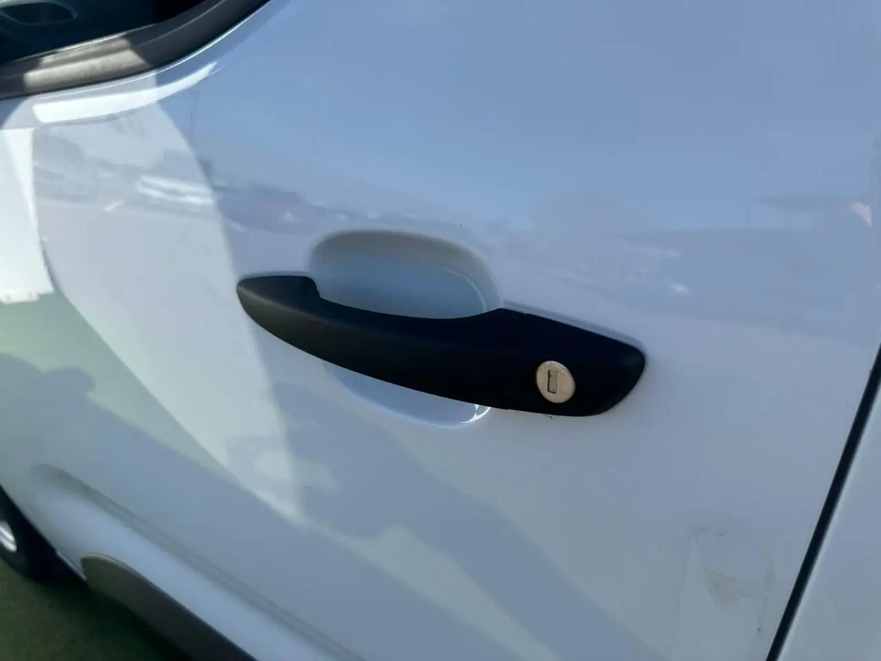 Poignée de porte noire côté droit sur porte blanche Icy d'un Citroën Berlingo III Van Taille M 2026.