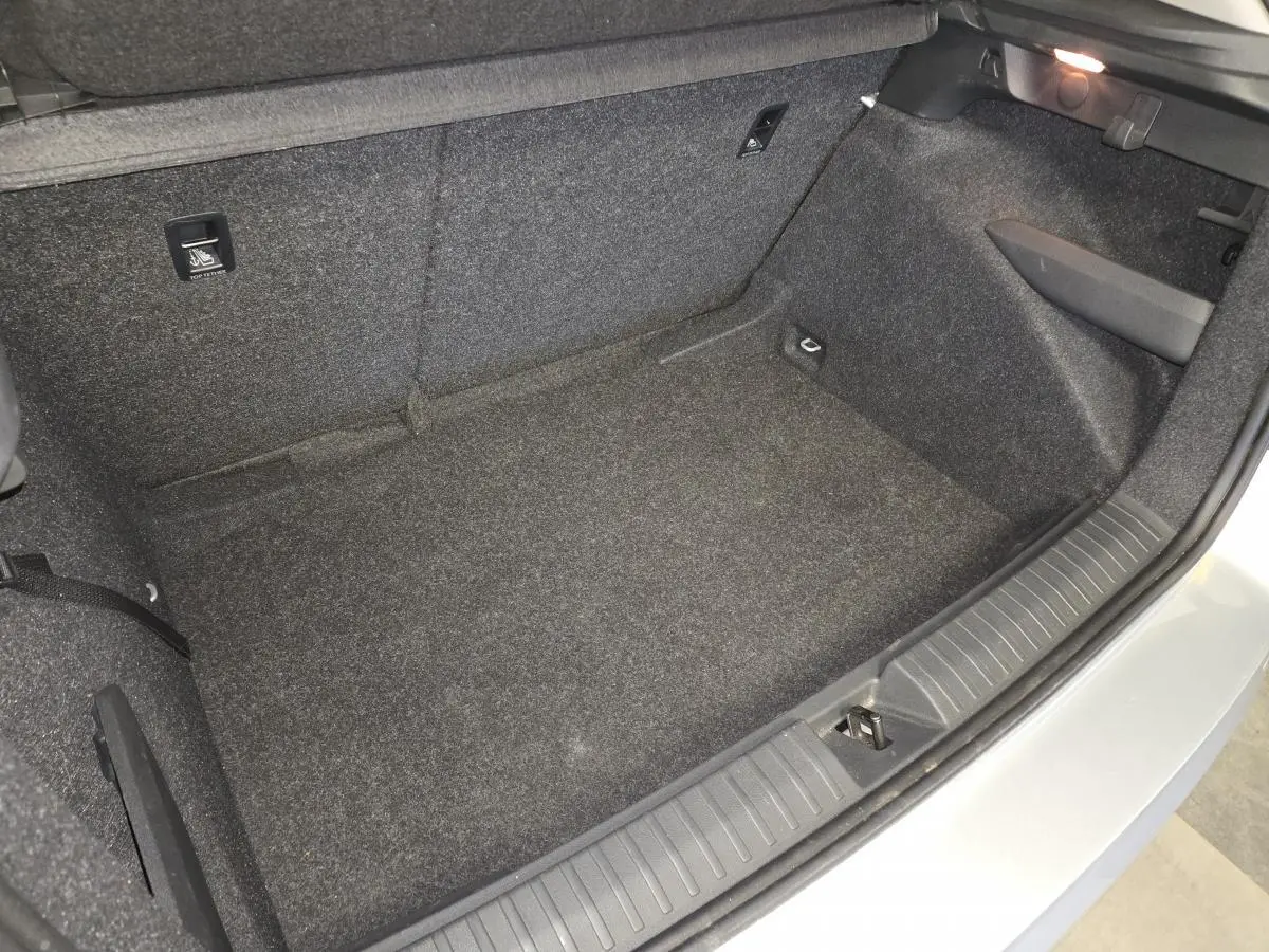 Vue rapprochée de l'intérieur du coffre gris clair du Skoda Kamiq 2023, montrant le revêtement et les fixations ISOFIX.