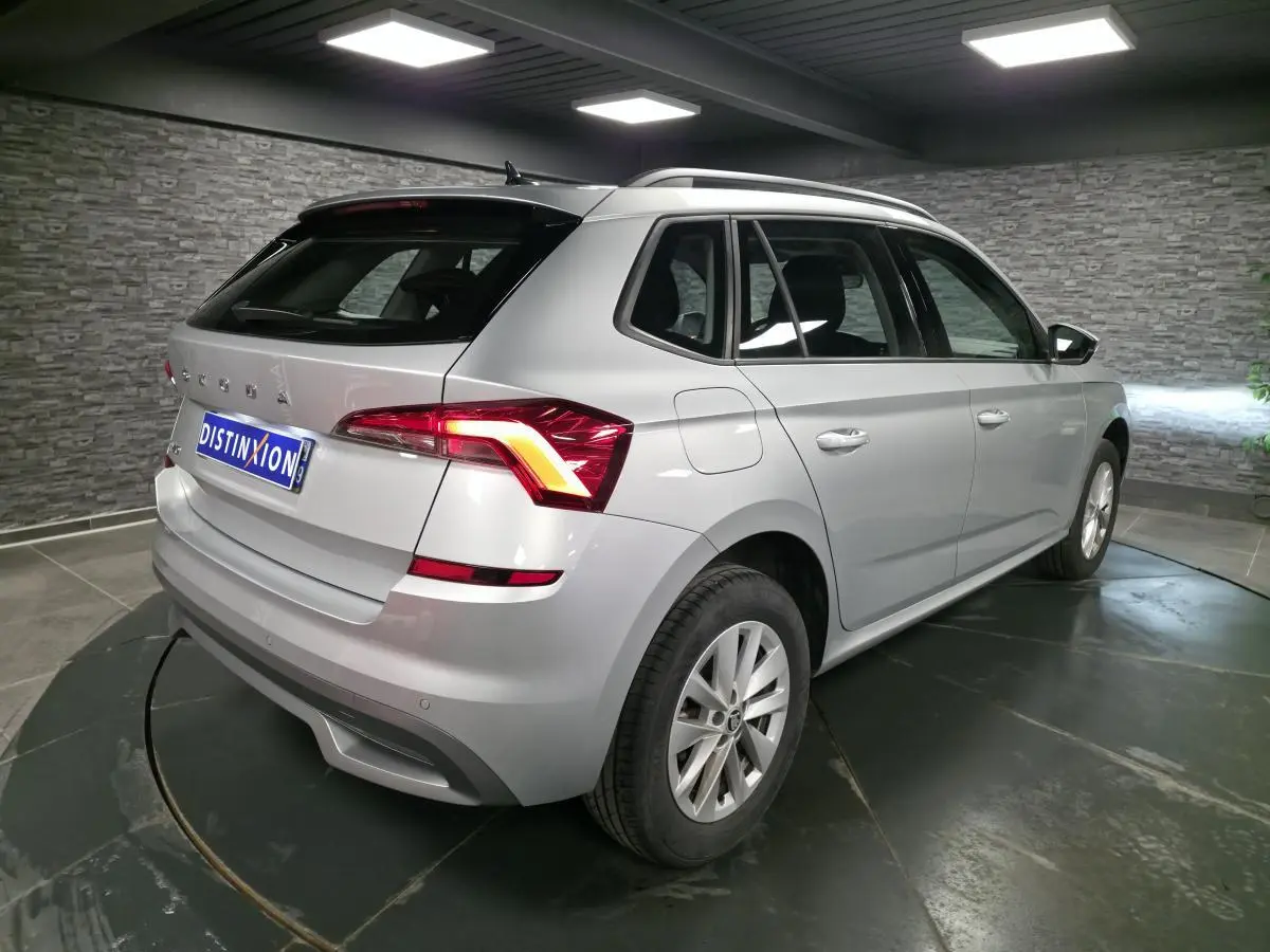 Vue 3/4 arrière droite d'un Skoda Kamiq gris métallisé 2023 avec feux arrière LED et jantes alliage 16 pouces.