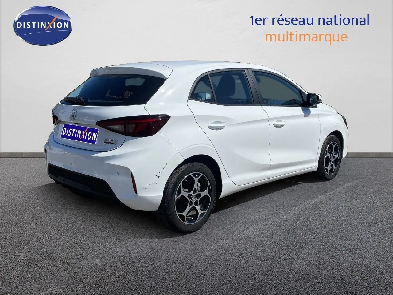 Vue 3/4 arrière droite de la MG3 1.5L Hybrid+ 195ch en blanc Dover avec jantes alliage bicolores et feux arrière foncés.