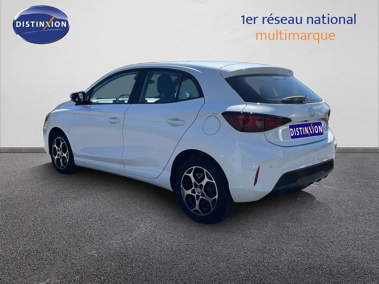 Vue 3/4 arrière droite d'une MG3 Dover White 2025, compacte hybride avec jantes alliage et feux arrière fumés.
