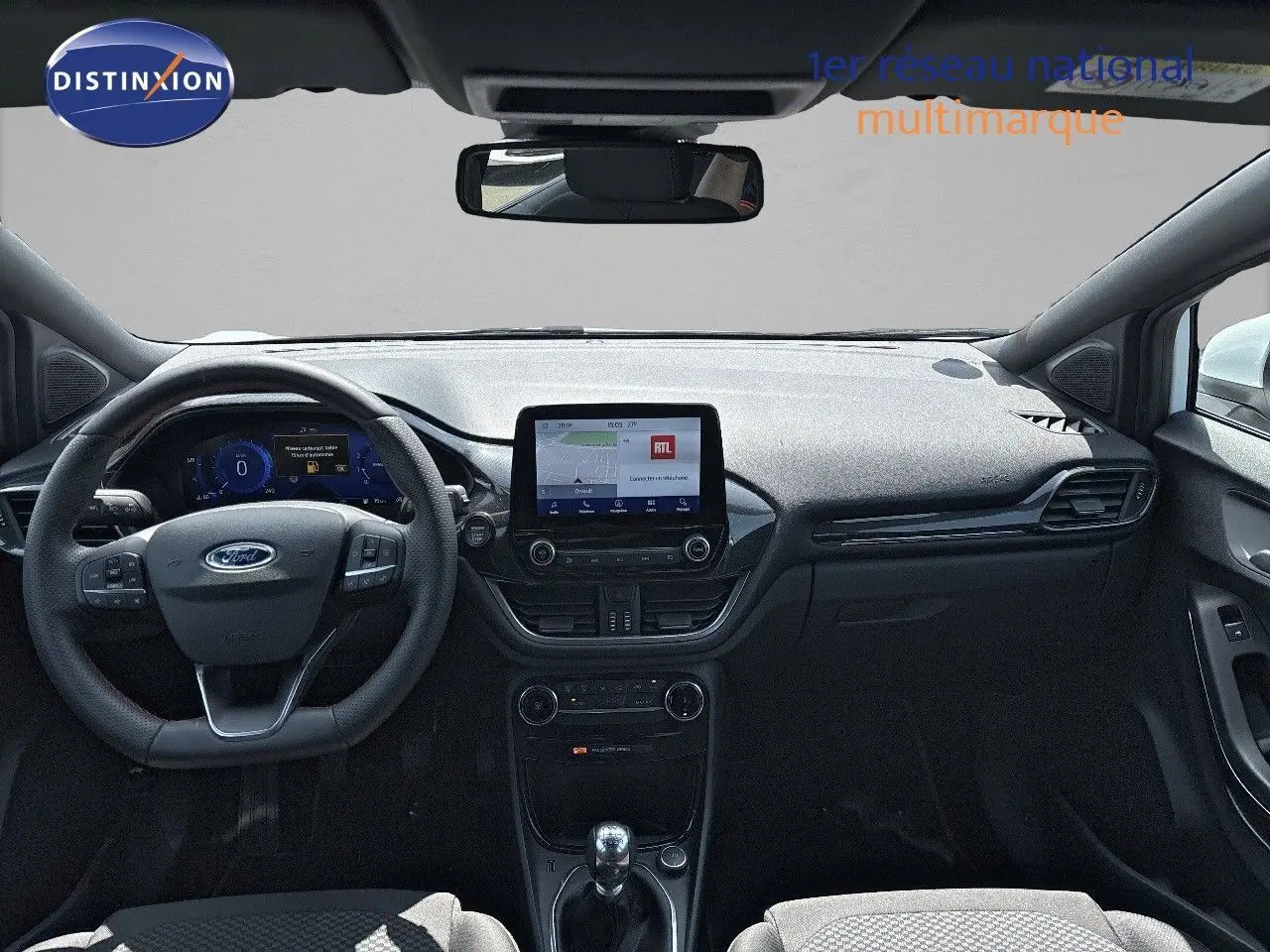 Vue intérieure frontale du tableau de bord noir du Ford Puma blanc 2022 avec écran tactile et volant multifonction.