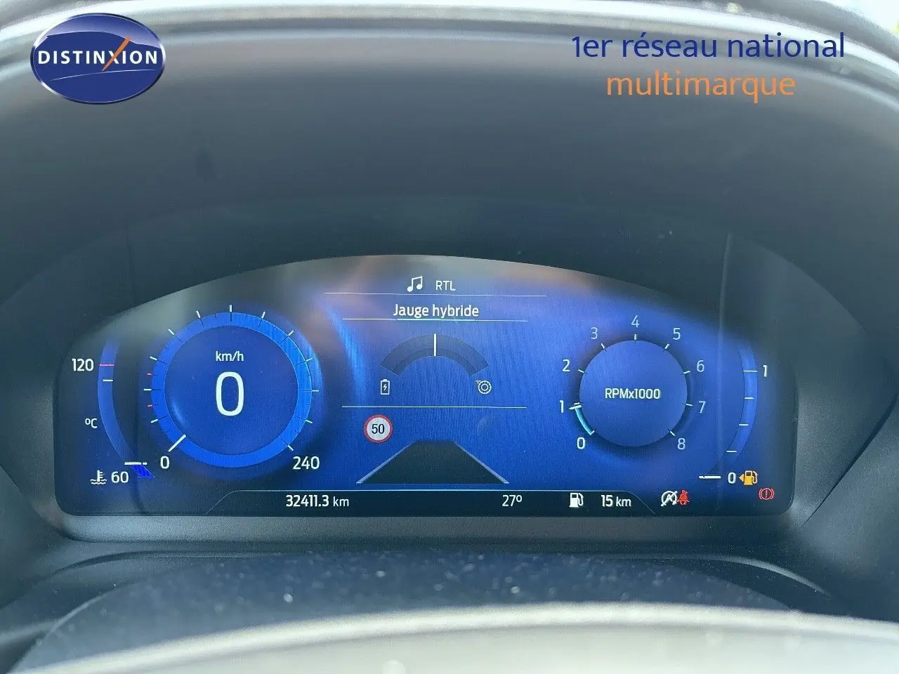 Tableau de bord numérique bleu du Ford Puma 2022 affichant vitesse, compte-tours et jauge hybride à l'arrêt.