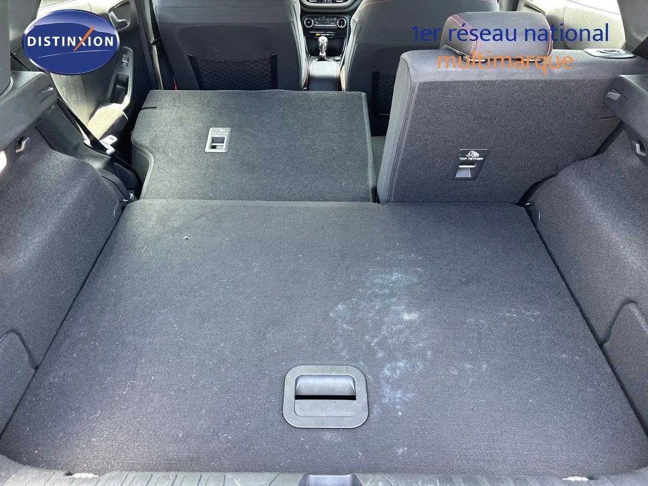 Vue sur le coffre du Ford Puma blanc 2022 avec banquette arrière droite relevée et gauche rabattue, montrant l'espace modulable.