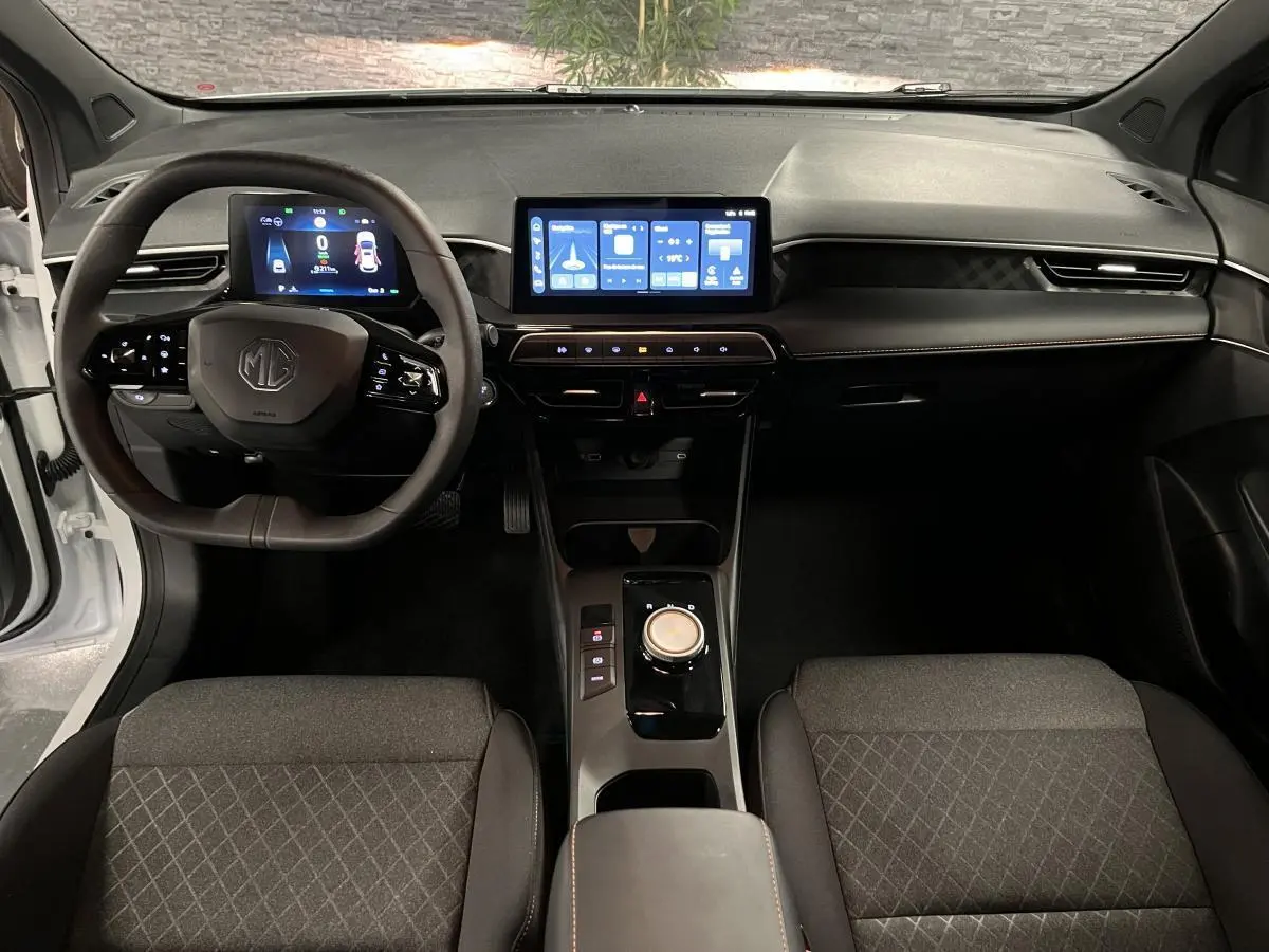 Intérieur de la MG3 1.5 Hybrid+ 2024 vue de face, tableau de bord noir avec écran tactile central et volant multifonction.
