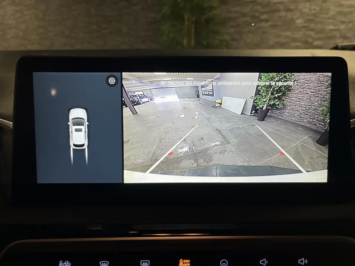 Écran de caméra de recul et vue aérienne du MG3 blanc 2024, montrant l'arrière du véhicule en stationnement.