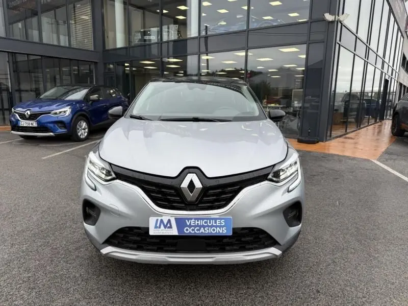Vue de face d'un Renault Captur E-Tech 145 Zen gris métal 2022, avec calandre noire et plaque "Véhicules Occasions" visible.