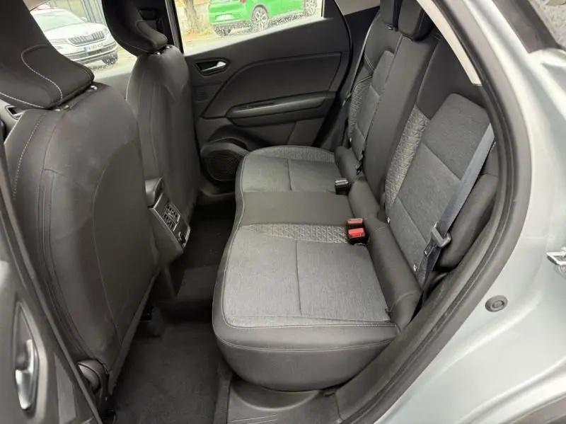 Vue intérieure arrière côté droit du Renault Captur E-Tech 145 Zen 2022 gris métal, sièges tissu gris avec motifs géométriques.
