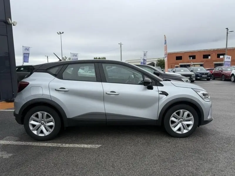 Profil côté gauche du Renault Captur E-Tech 145 Zen gris métal 2022, avec toit noir contrasté et jantes alliage visibles.