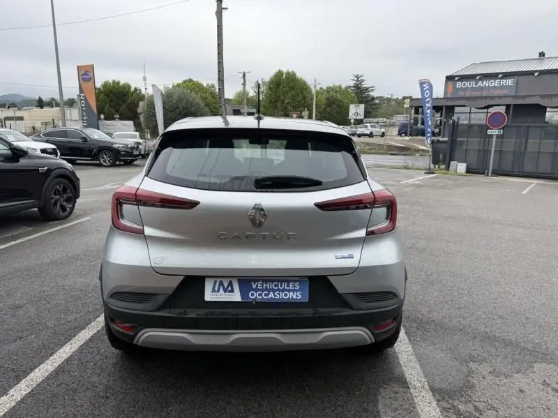 Vue arrière d'un Renault Captur E-Tech 145 Zen gris métal 2022, avec feux arrière allongés et plaque d'occasion visible.
