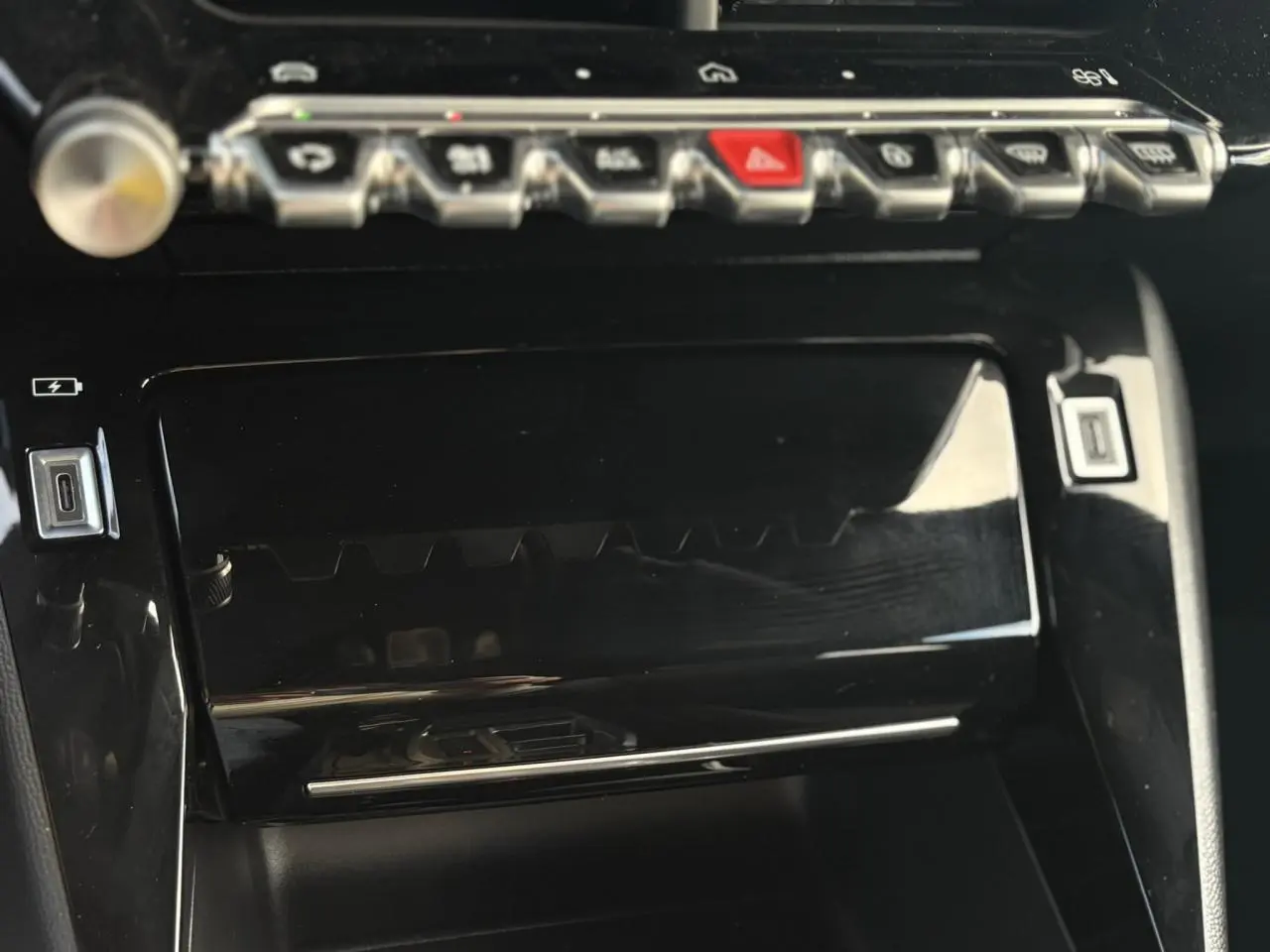 Gros plan sur la console centrale noire brillante du Peugeot 2008 Hybrid 145 e-DSC6 Allure, avec commandes tactiles et ports USB-C.