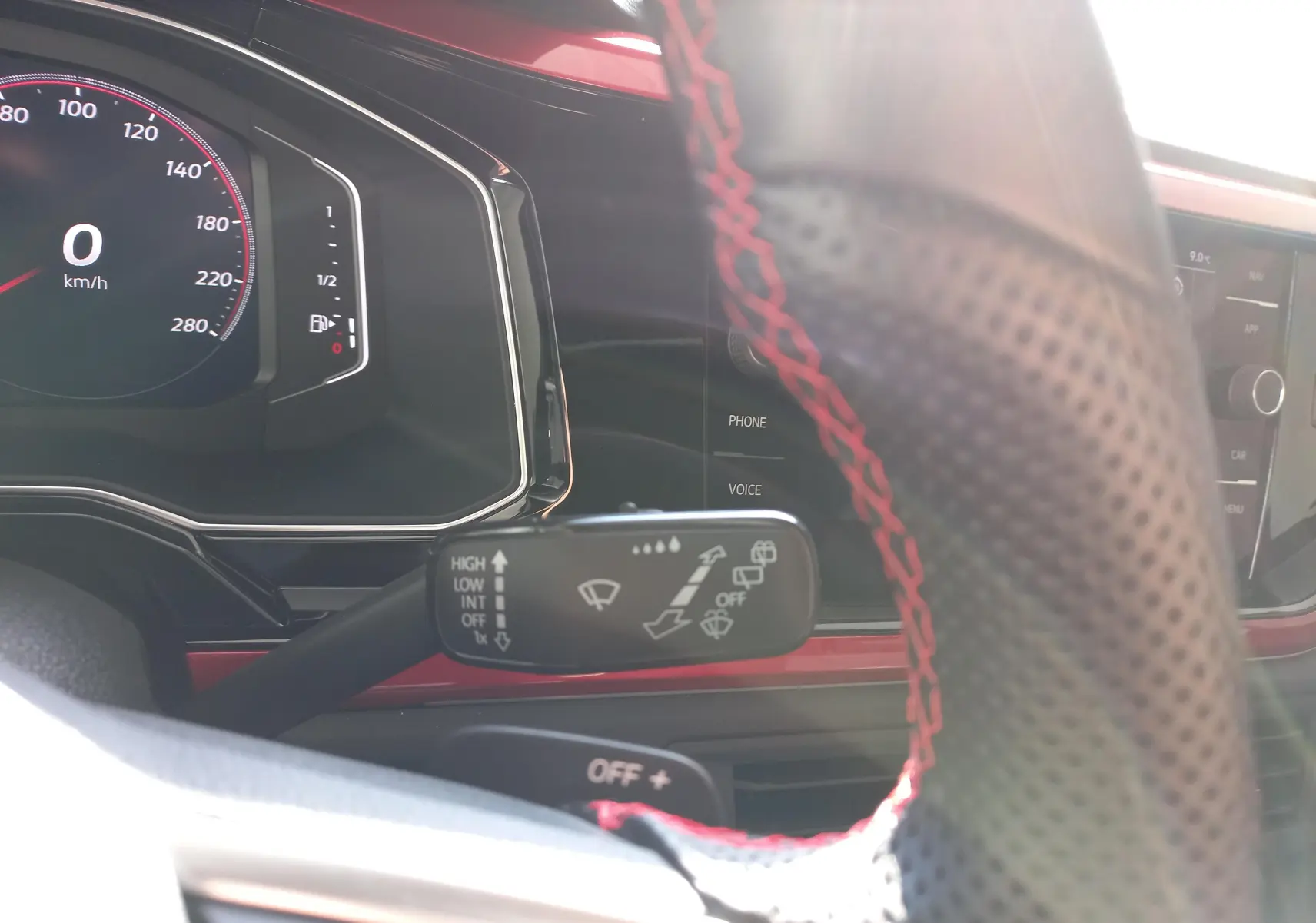 Vue rapprochée du tableau de bord et du volant perforé avec surpiqûres rouges de la Volkswagen Polo GTI 2024.