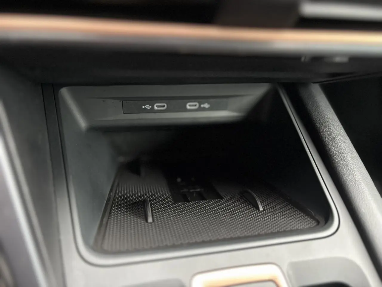 Gros plan sur la console centrale du CUPRA LEON ST 2025 avec deux ports USB-C et surface de charge noire texturée.
