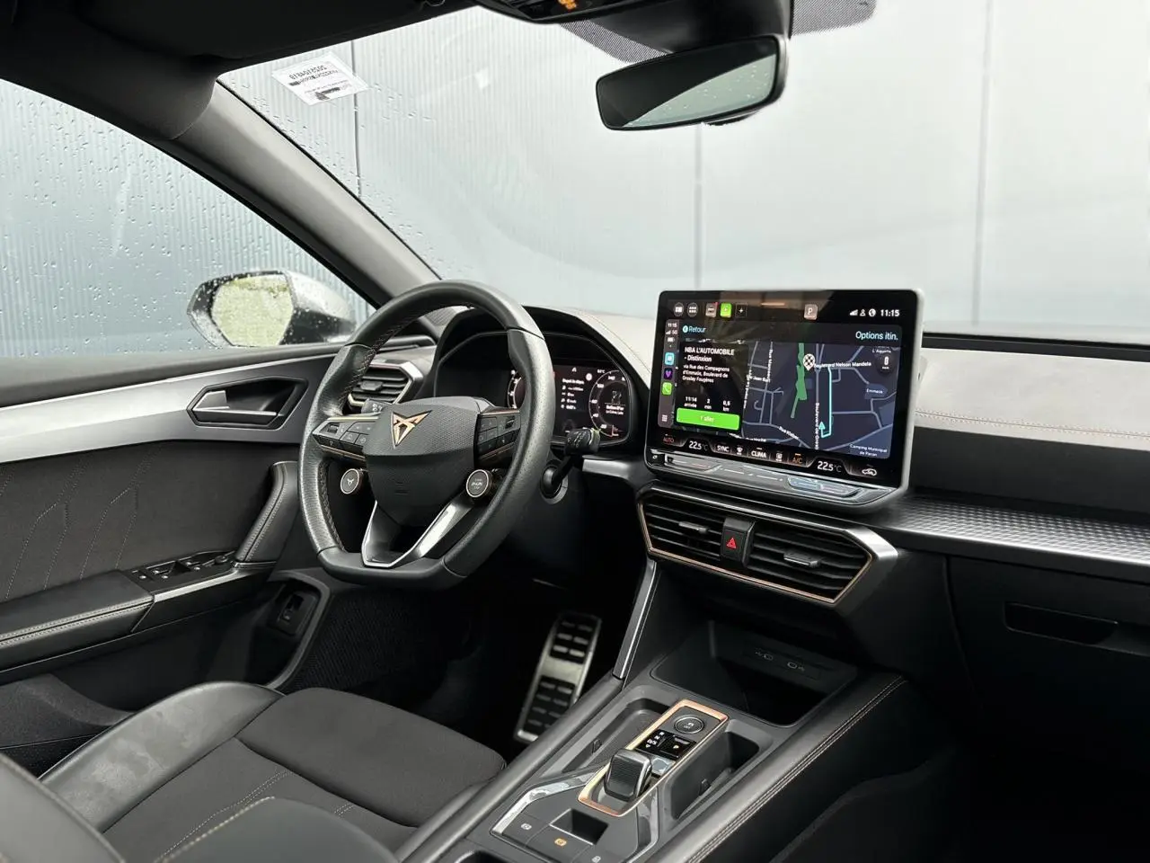 Vue intérieure côté conducteur du CUPRA LEON ST 2025, avec volant cuir, écran tactile HD et finition noire élégante.