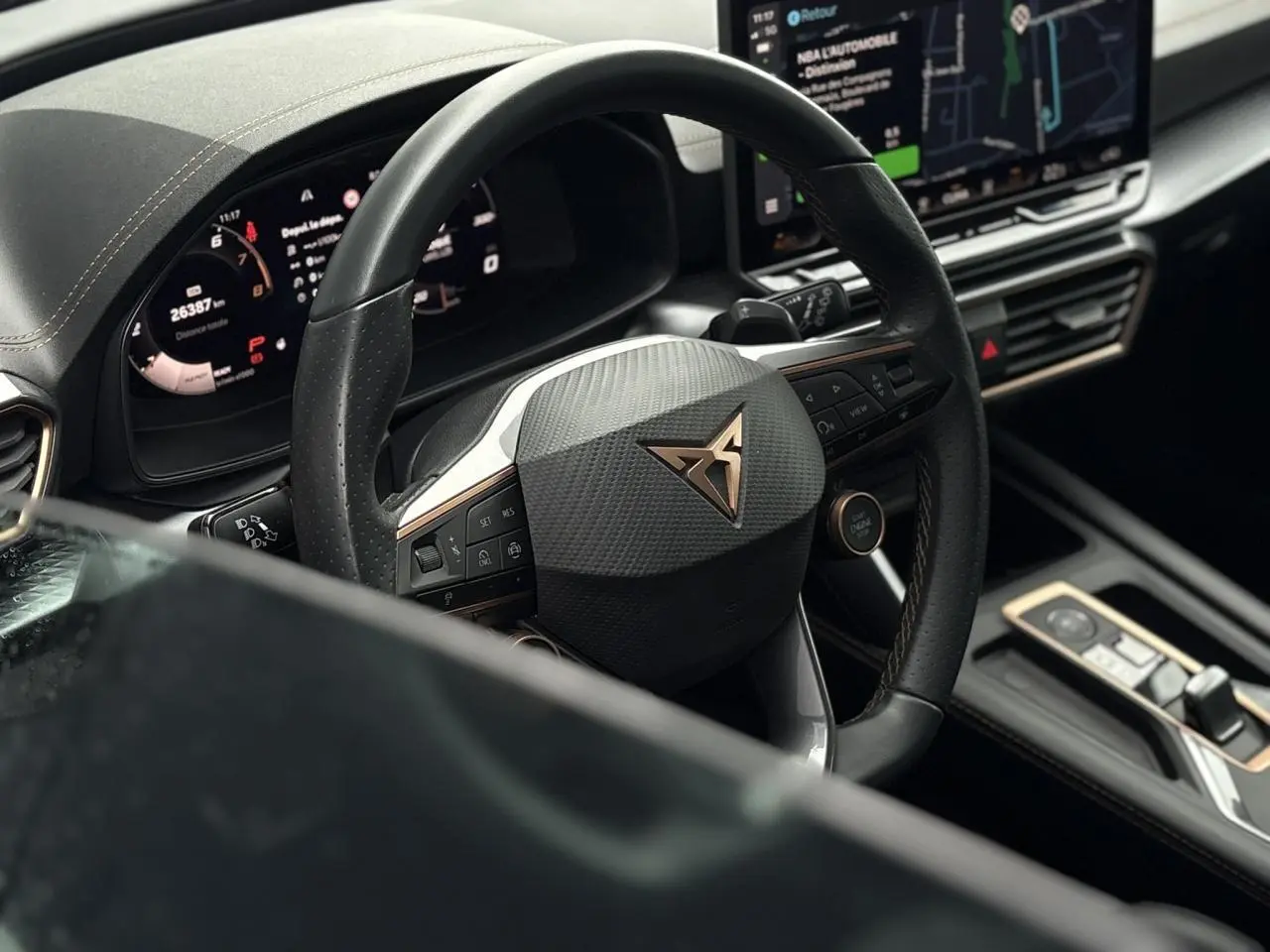 Vue rapprochée du volant noir avec logo CUPRA cuivré et tableau de bord numérique d'une CUPRA LEON ST 2025.