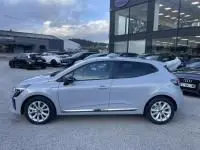 Renault Clio V DCI 100 Evolution gris métal vue 3/4 avant droit, avec feux LED et jantes alliage visibles.