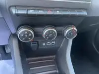 Gros plan sur le levier de vitesse manuel noir de la Renault Clio V DCI 100 Evolution 2025, intérieur gris et noir.