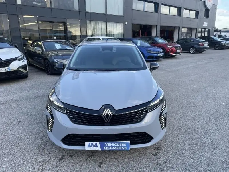 Vue avant frontale d'une Renault Clio V DCI 100 Evolution gris métal 2025, avec calandre noire et feux LED verticaux.