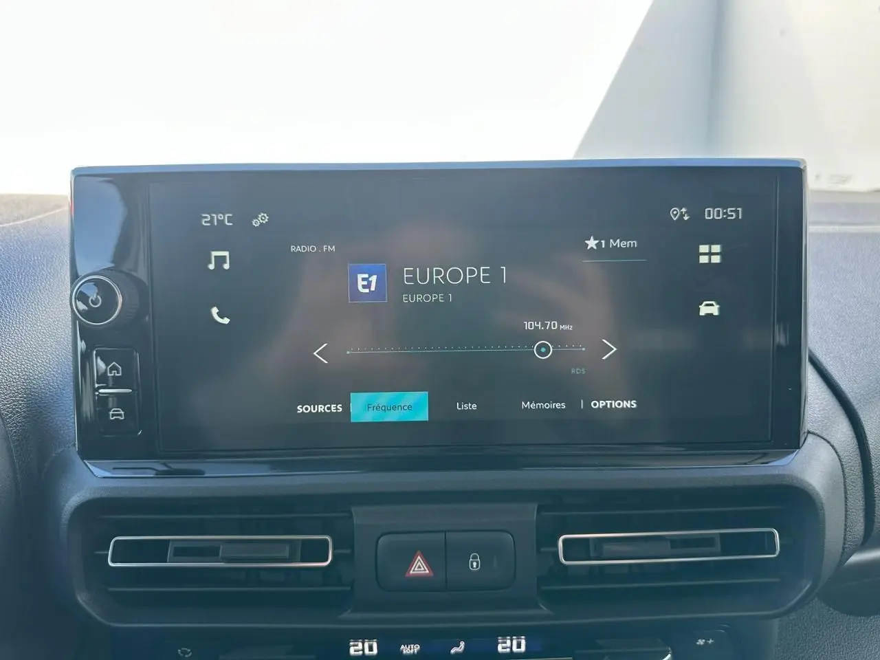 Écran tactile 10 pouces affichant la radio Europe 1, tableau de bord noir du Citroën Berlingo blanc, vue intérieure frontale.