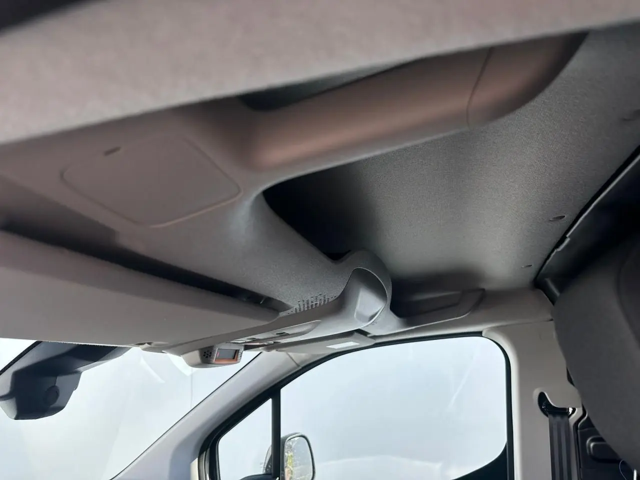 Vue intérieure côté conducteur du plafond et pare-soleil du Citroën Berlingo III blanc Icy, avec rétroviseur et partie de siège visible.